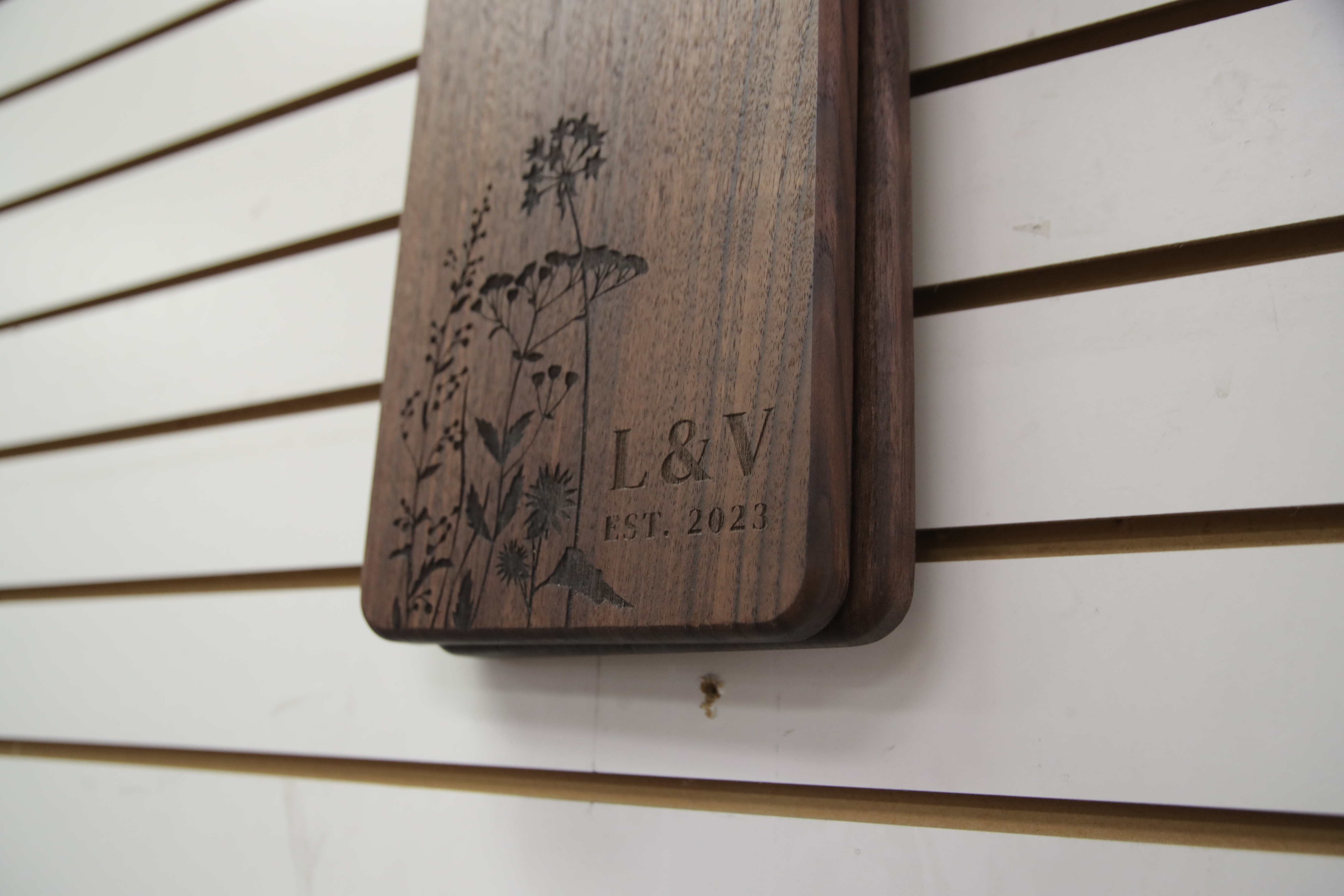 Personalized wooden cutting board with laser-engraved floral design and initials