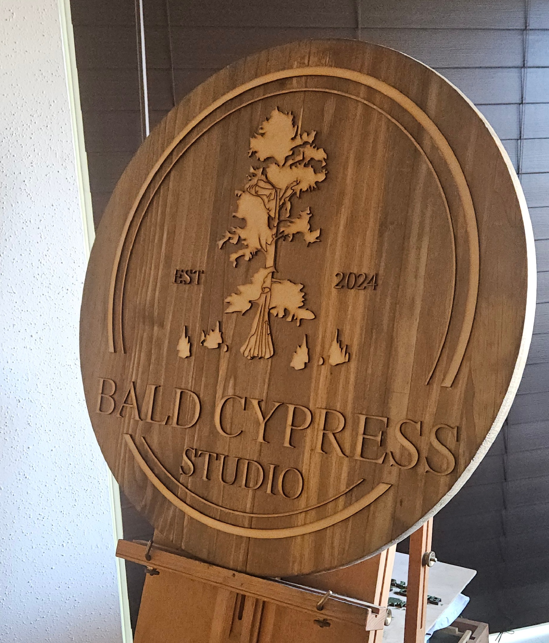 Custom wooden business sign for Bald Cypress Studio featuring laser-engraved logo and tree design